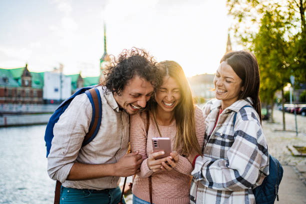 istock Tourists laughing while looking at smartphone in Copenhagen, Denmark 2199451323