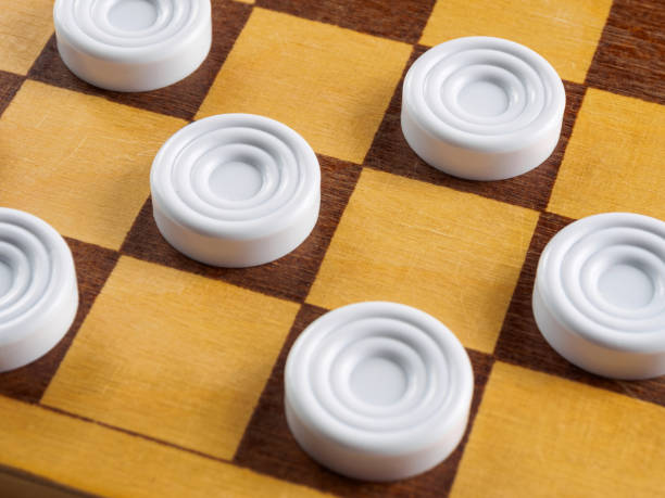 istock Checkers game setup on a checkered board. Strategy, game pieces, black and red, ready to play, board game. 2199452326