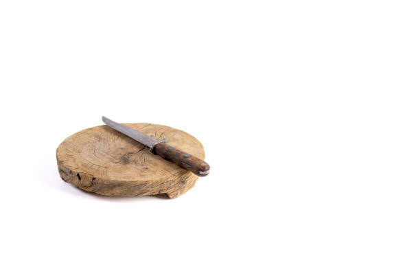 Round empty wooden cutting block with hunters knife. White Background