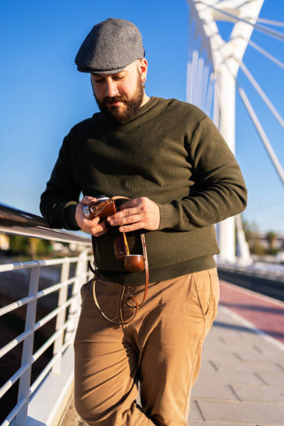 istock Photographer preparing vintage camera on modern bridge 2199455486