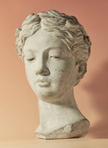 Stone head sculpture gently illuminated, set against a warm background evoking classical aesthetics. Perfect in a private garden setting or for showcasing Latin influences in Denmark-inspired decor.