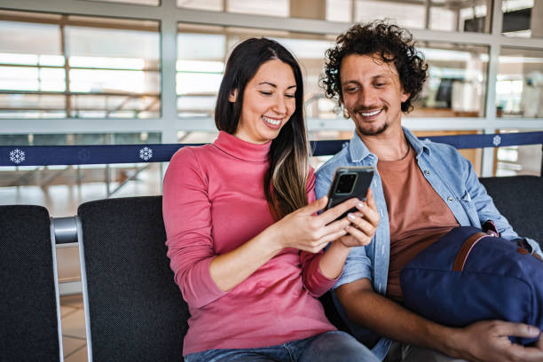 istock Young couple using smartphone while waiting at Malmo airport 2199456508