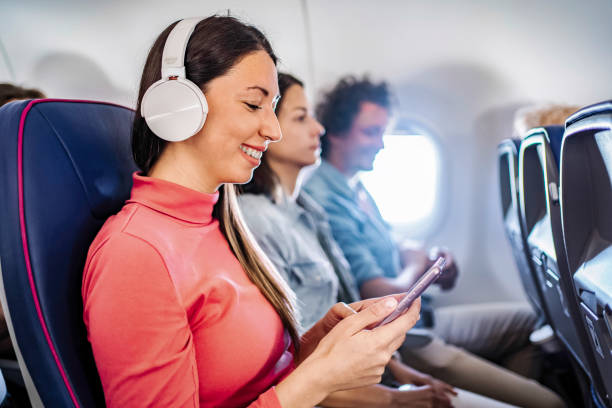 istock Tourist enjoying music and using smartphone while traveling by airplane 2199456553