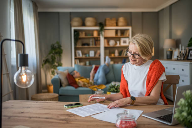 istock Senior woman working from home while granddaughter reads 2199459027