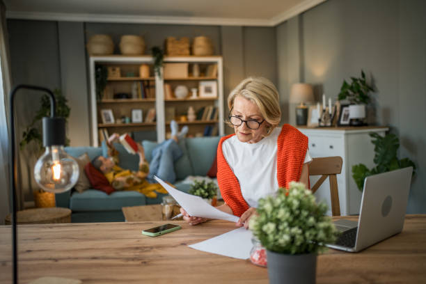 istock Senior woman working from home while granddaughter reads 2199459041