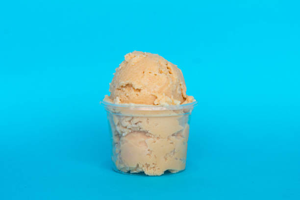 istock Caramel ice cream melting in a plastic cup on vibrant blue background 2199460579