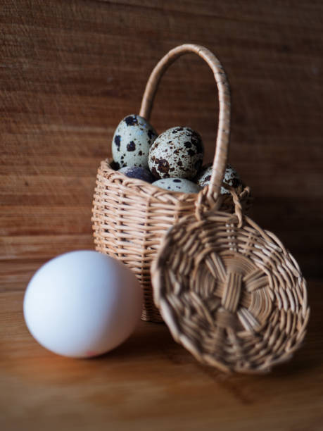 Fresh Quail Eggs in Wicker Basket on Wooden Surface