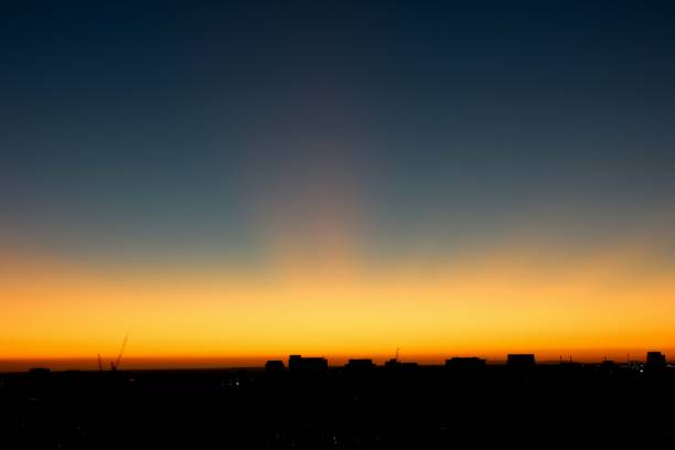 Sunset over Port Phillip Bay with a sunray into the sky and the shadow of St Kilda road towers below