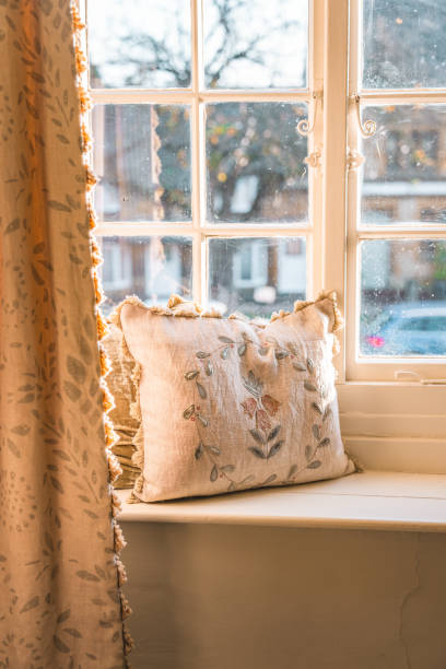 istock Sunlight illuminating cozy window sill with cushions in cotswolds cottage 2199467078