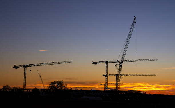 istock Silhouettes of construction cranes against the evening sky with sunset 2199467895