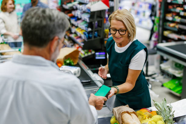 istock Customer paying with smartphone at supermarket checkout 2199471076