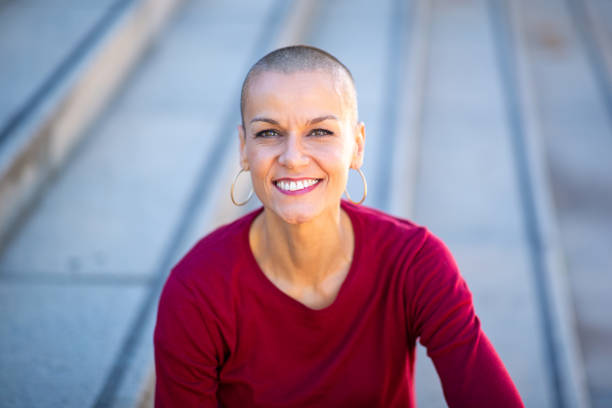 istock Close up older woman with shaved head smiling 2199471989