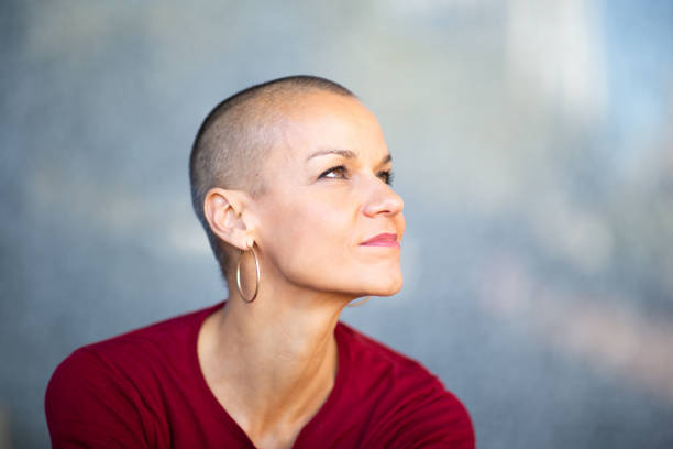 istock woman with shaved head looking away 2199472029