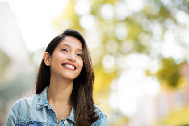 istock Close up smiling young woman outdoors looking away 2199472391