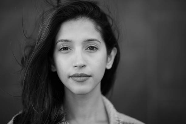 Close up black and white portrait serious young woman staring