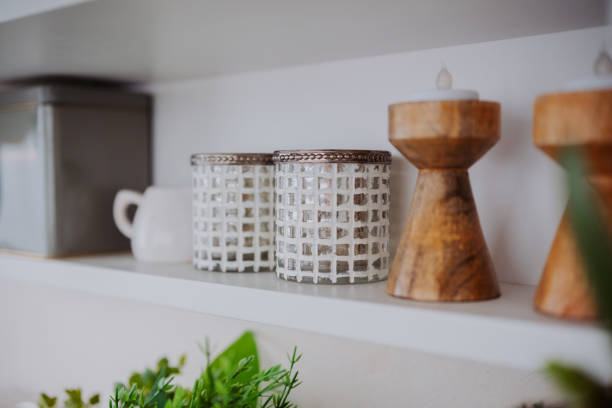 istock Decorative items on a shelf with glass jars, candles, and greenery 2199472597