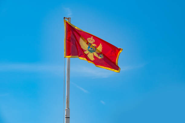 istock modern Montenegrin flag wave against bright blue sky, showcasing national pride, concept tourism, emigration, economy and politics 2199473733