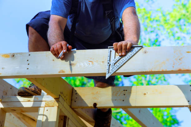 istock Skilled carpenter measures wood for construction on a sunny day at a building site in summer 2199476367