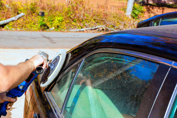 istock Car detailing process in sunny outdoor setting with a focus on polishing the vehicle's surface 2199476431