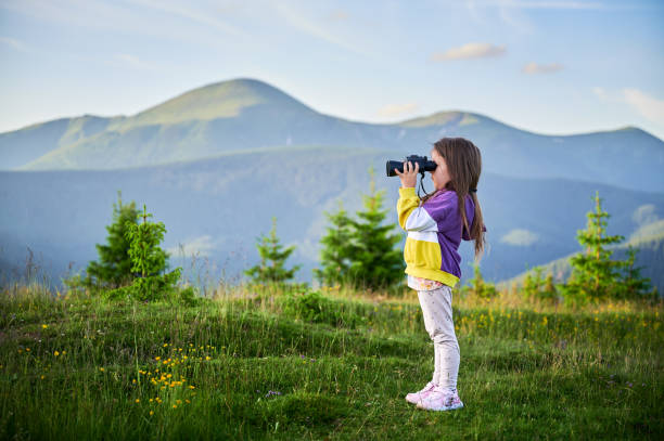 child looking into the distance with binoculars
