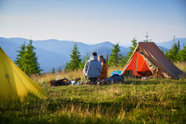 istock Two campers enjoying serene view of rolling mountains under clear sky. 2199486354