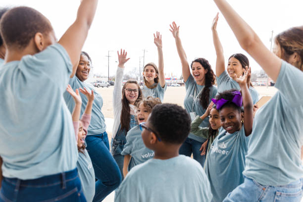 istock Joyful Volunteers and Children Celebrating Teamwork 2199488579