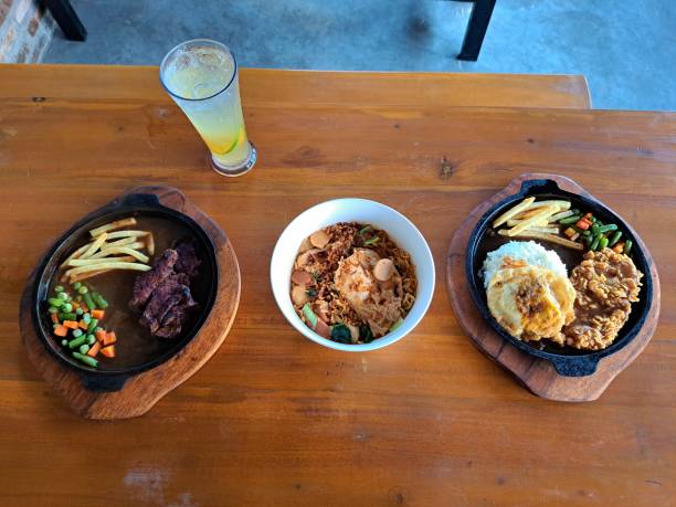 istock Pan Seared Beef Steak, Mi Goreng Telur Or Fried Noodle Egg And Crispy Rice Egg Chicken Steak. Es Jeruk Segar Or Fresh Orange Iced In Juice Glass. Food And Drink Menu. 2199494049