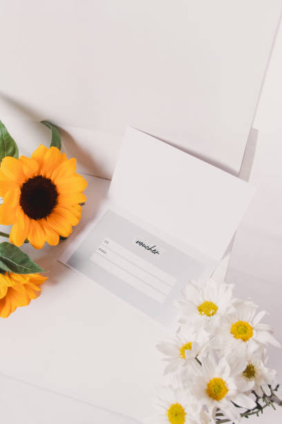 istock Gift card surrounded by flowers and sunflowers on a white background. 2199494650