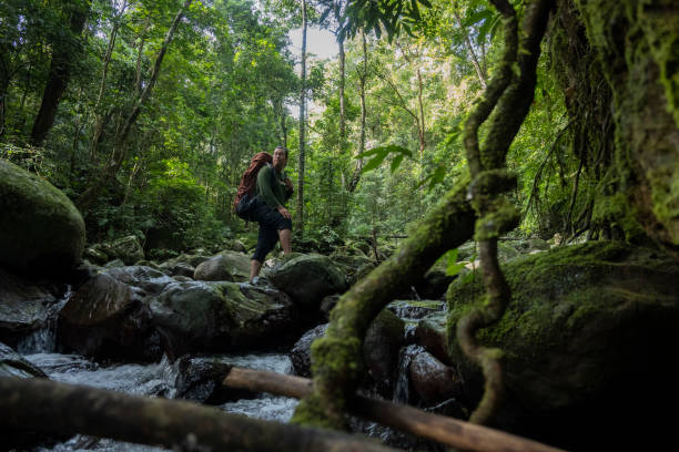 istock Man with backpack walking in the river-Stock Photo 2199505387