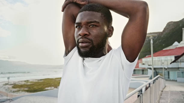 istock Young African man stretching his arms before a morning run 2199509892