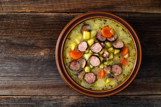 Potato soup with sausage on wooden table