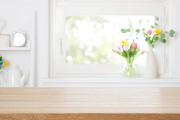 istock Empty wooden table top with free space on blurred decorated with colorful spring flowers window background 2199523972