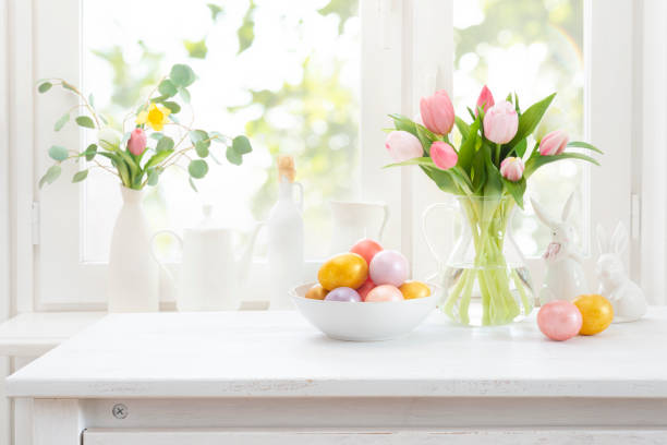 istock Vintage Easter table decoration with copy space on blurred interior of spring flowers and window 2199523977