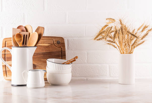 istock Stylish white kitchen background with kitchen utensils on a marble countertop. ceramic bowls, a jug, cutting boards, a vase with ears. Eco style. 2199527489