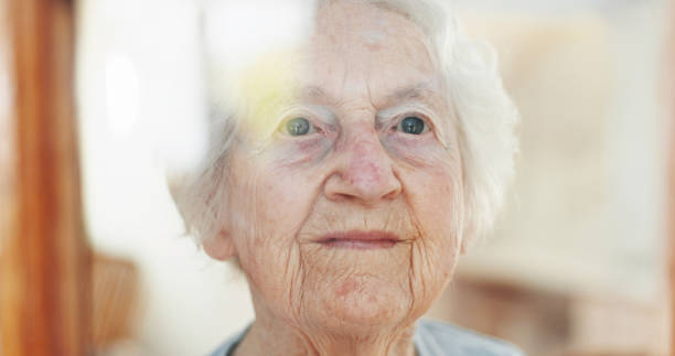 istock Thinking, window and idea with old woman in living room for memory, reflection and mindfulness. Peace, inspiration and vision with senior person in nursing home for retirement, decision and wonder 2199533017
