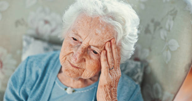 istock Thinking, sad and memory with old woman on sofa for reflection, Alzheimer and mindset. Depression, tired and retirement with senior person in living room of nursing home for mental health and vision 2199533112