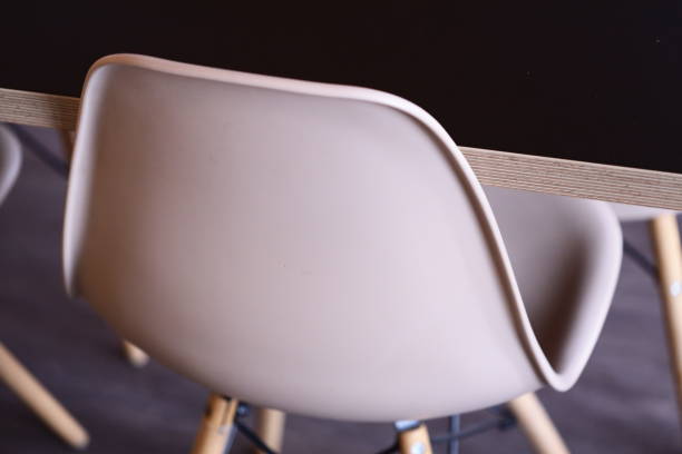 Simple furniture setting with a white chair and wooden table, ideal for home or office use