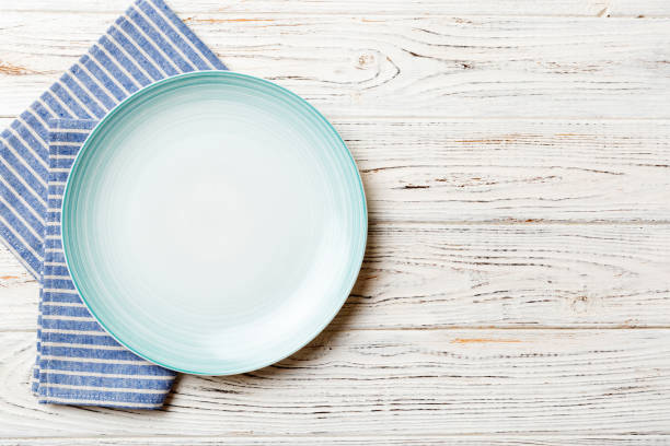 istock Top view on colored background empty round blue plate on tablecloth for food. Empty dish on napkin with space for your design 2199538774