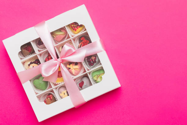 istock Box with sweet chocolate candies on color background, Various candy sweets. Valentines day gift box. Top view flat lay with copy space 2199539092