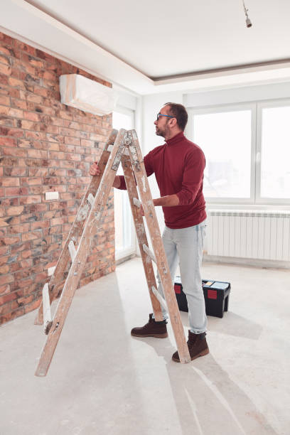 istock Handyman electrician with ladders working in a new home interior. 2199545717