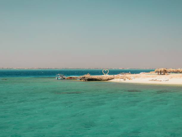 istock Scenic beach with turquoise water and heart sculpture. 2199545799