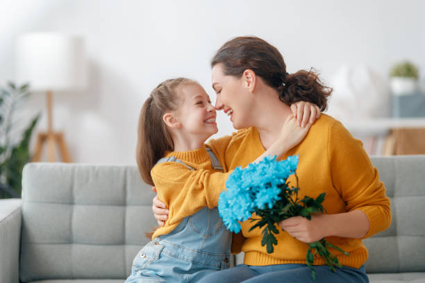 istock daughter is congratulating mom and giving her flowers 2199551905
