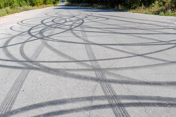 istock Skid marks on the road surface. Circular tire tracks left by drivers making donuts. Tire print on asphalt road 2199552349