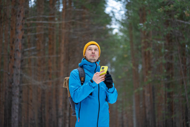 istock Hiker using smartphone gps app in snowy winter forest 2199553872
