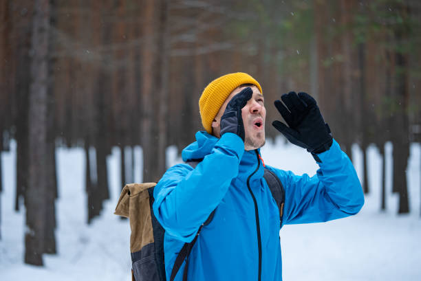 istock Hiker shouting in snowy forest wearing backpack and winter clothes 2199554854