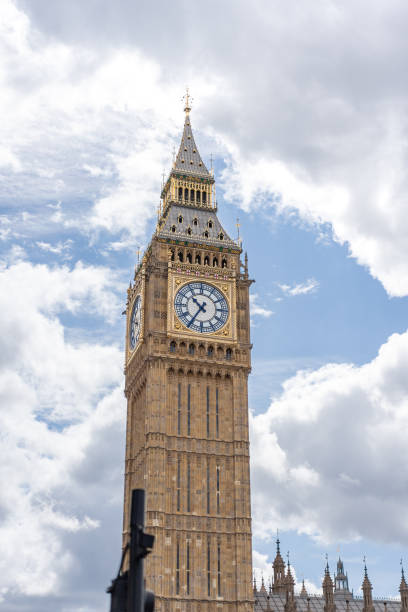 istock Big Ben iconic clock tower bathed in daylight, emphasizing the golden accents and intricate design against the backdrop of a cloudy sky, for promoting London historic landmarks. 2199556048