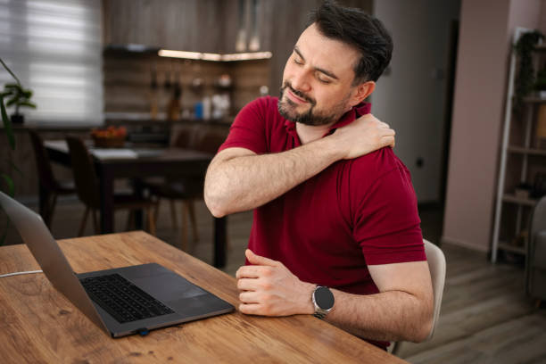 istock Man working from home suffering from neck pain 2199558054