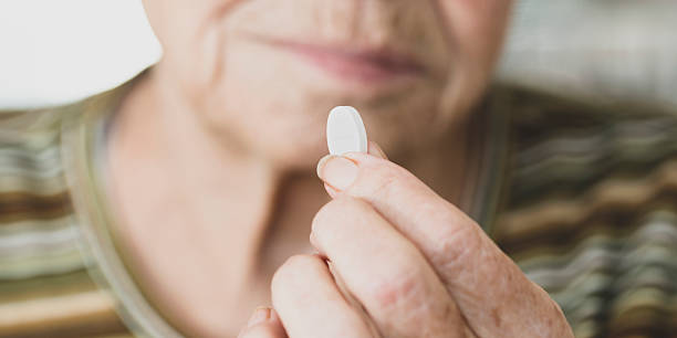 istock Senior woman taking pills, selective focus, blurred background 2199559400