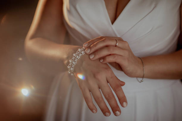 istock Bride puts on a wedding bracelet with rhinestones on her hand 2199559683