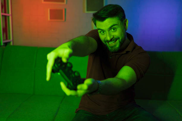 istock Young man having fun playing video games at home 2199560085